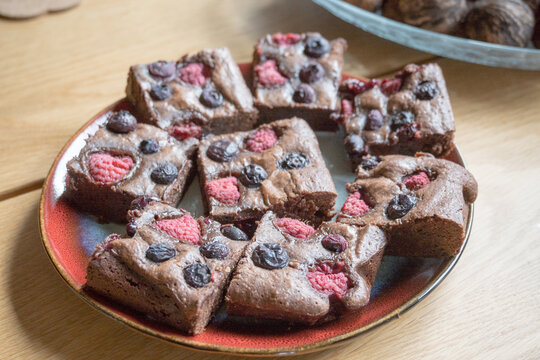 Homemade chocolate brownies with raspberries and blueberries.
