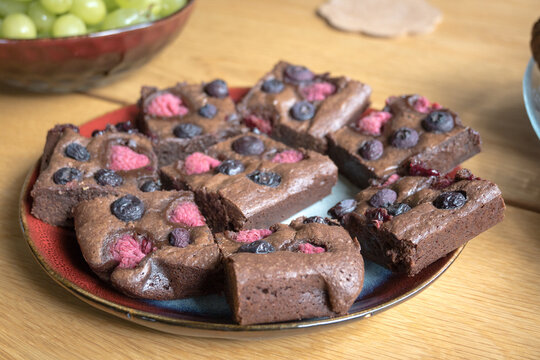 Homemade chocolate brownies with raspberries and blueberries.
