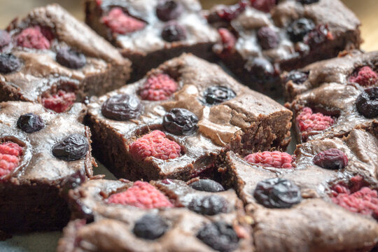 Homemade chocolate brownies with raspberries and blueberries.
