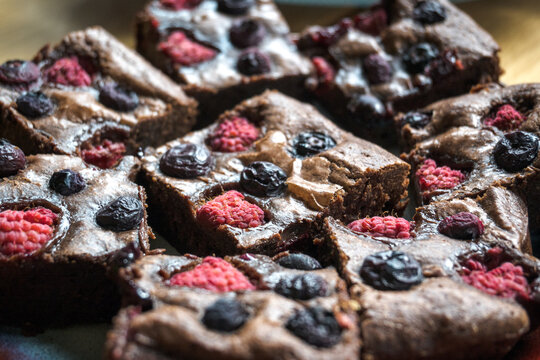 Homemade chocolate brownies with raspberries and blueberries.
