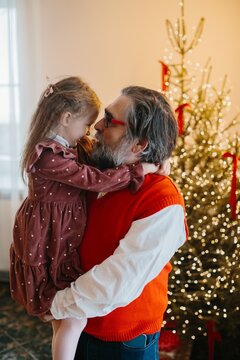 Grandfather hugging granddaughter celebrating christmas holidays together