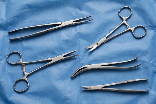 Set of various surgical instruments including forceps and scissors on a blue sterile surgical drape