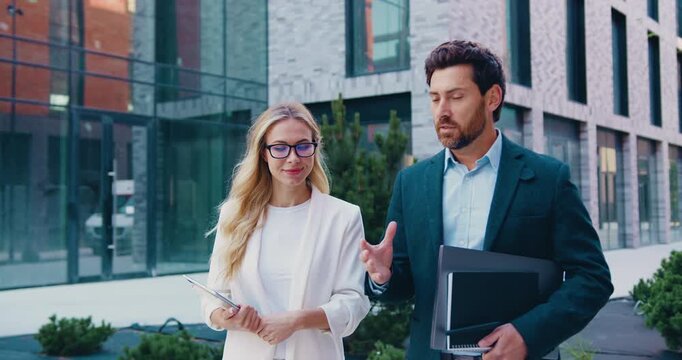 Businessman and businesswoman having a professional conversation outdoors