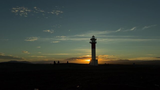 Sunset Silhouettes by Fangar Lighthouse on Dark Sand Beach
