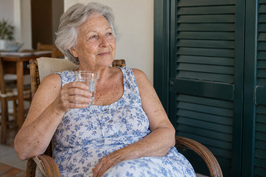Older woman holding a glass of water during hot weather