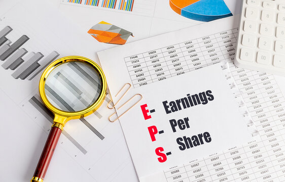 Earnings per share financial analysis with magnifying glass, calculator, charts and accounting documents