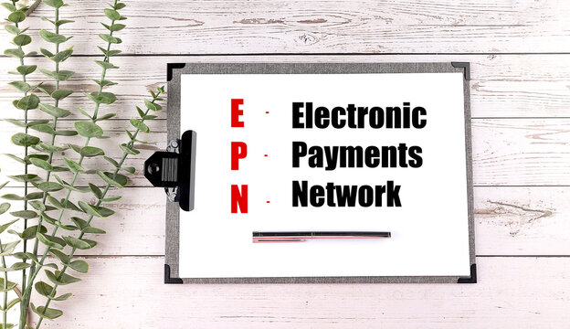 Electronic payments network text on a clipboard with pen and leaves on a wooden desk, epn banking and finance concept