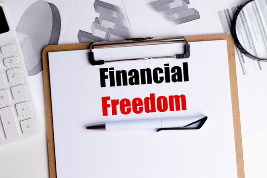 Financial freedom concept with calculator, charts, clipboard and pen on desk