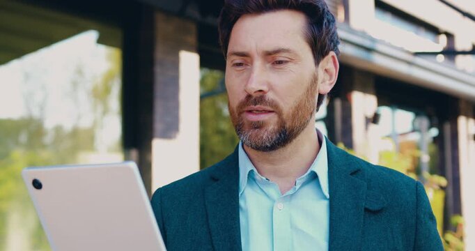 Portrait of businessman using tablet for video call outdoors