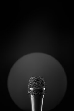 Microphone in a circular spotlight on a dark stage