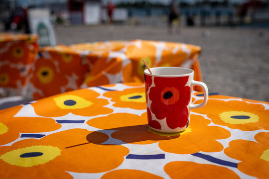 Bright floral cafe setting with a patterned mug on an outdoor table in Helsinki, Finland
