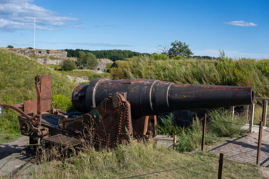 Historic coastal cannon at Suomenlinna fortress in Helsinki, Finland under a clear blue sky