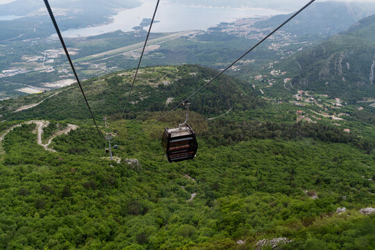 Cable car cabin moving above deep green gorge in mountains