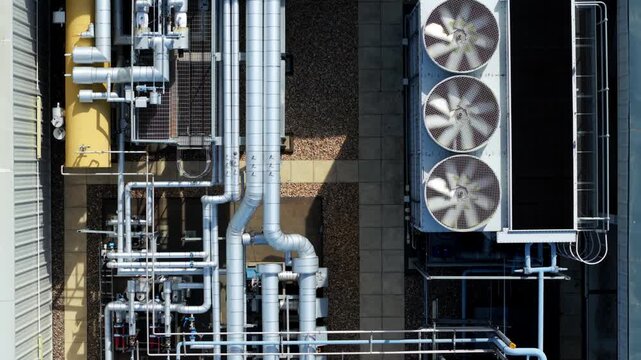 Top down aerial view of industrial factory rooftop HVAC ventilation fans and pipework in Luton, UK
