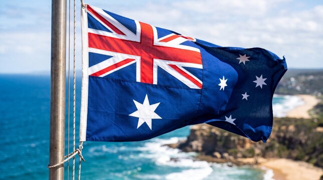 Australian Flag Waving on Flagpole Against Coastal Ocean Landscape