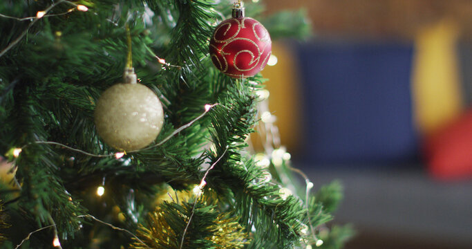 Image of christmas tree with baubles and fairy lights decorations on blurred background