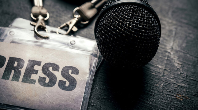 Highlighting global media safety, a press identification card and microphone stand for free speech on the International Day to End Impunity for Crimes against Journalists, urging justice