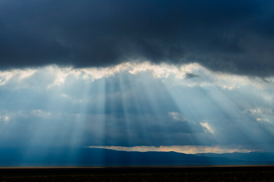 Sun rays breaking through clouds over Nevada mountains