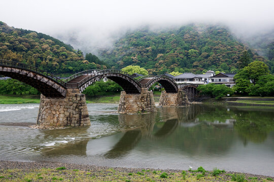 Kintai bridge spanning a foggy river with mountains, japan