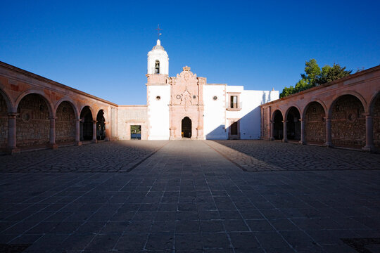 Church courtyard with bell tower and stone arches