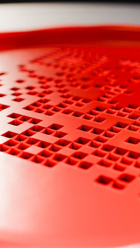 Red plastic surface with geometric square hole pattern
