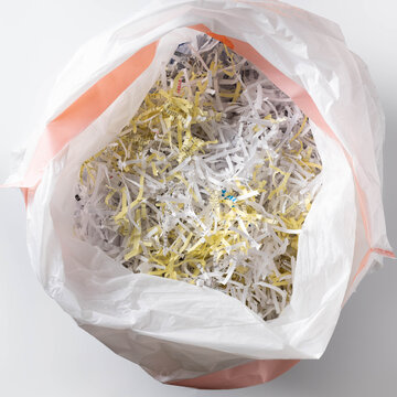 White plastic bag filled with shredded papers, documents, data security, recycling concepts.