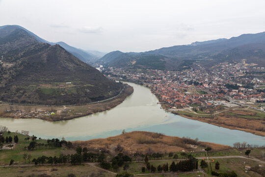 Confluence of two rivers winding through a mountain valley beside a town, Mtskheta-Mtianeti, Mtskheta, Georgia
