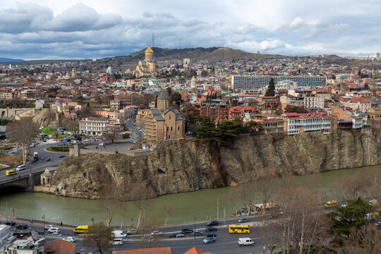 Metekhi Church on the cliff above the Kura river with Holy Trinity Cathedral beyond, Tbilisi, Georgia