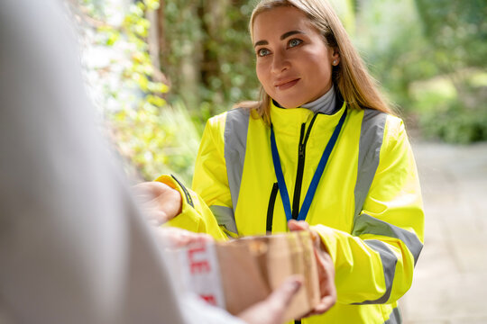 Delivery person brings a damaged, torn parcel to the recipient. courier spreads hands with an apologetic, guilty expression, suggesting delivery problem.