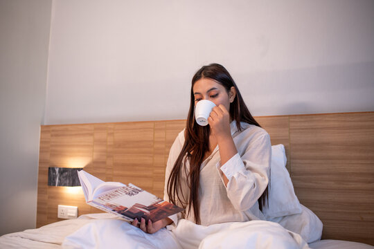 Young woman relaxing on bed while using reading enjoying learning and entertain story.	
