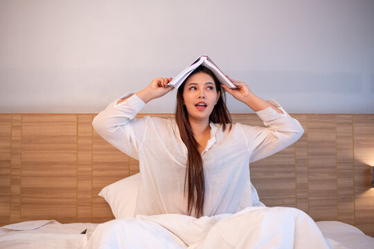 Young woman relaxing on bed while using reading enjoying learning and entertain story.	