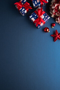 Merry Christmas and Happy Holidays greeting card, frame, banner. New Year. Red Christmas ornaments and gifts, presents on blue background top view. Xmas holiday festive theme. Christmas decoration.