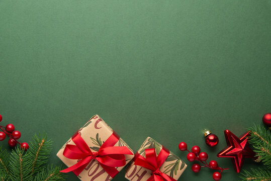 Merry Christmas and Happy Holidays greeting card, frame, banner. New Year. Red Christmas ornaments and gifts, presents on green background top view. Xmas holiday festive theme. Christmas decoration