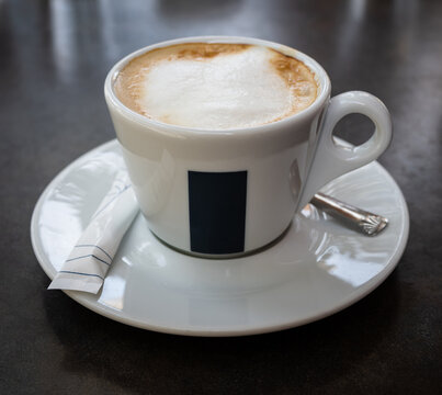 A hot cappuccino in a white porcelain cup.