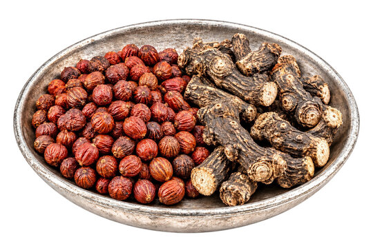 Dried vidanga berries and knotted pippali root pieces on antique pewter dish isolated on transparent background