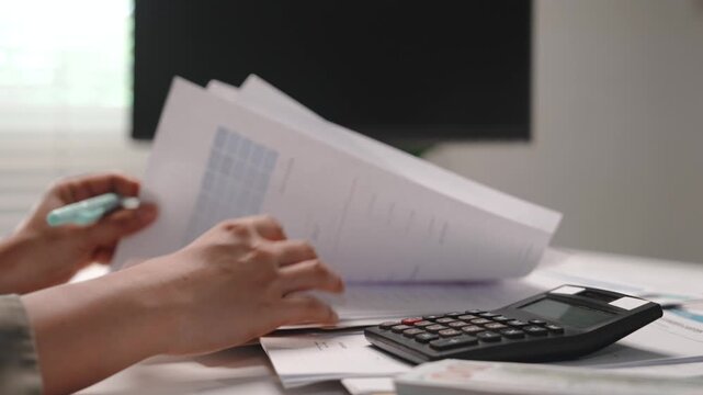 Accounting and finance, female accountant reviewing financial documents, flipping through paperwork and checking records at office desk, tax preparation, audit, balance sheet and year end reporting.