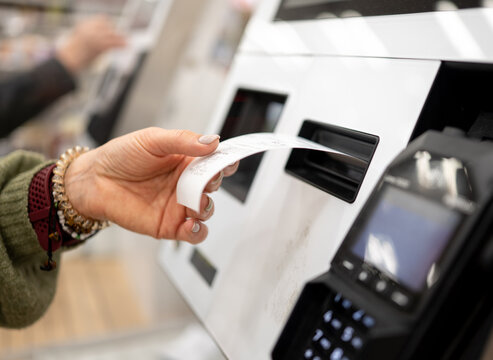 Woman Taking gas pump receipt outdoors