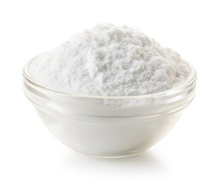 Transparent glass bowl of baking soda powder on white background