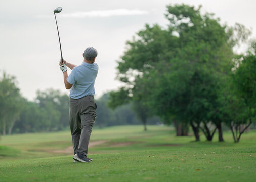 Active aging and golf friendship concept. Happy senior golfer shakes hands with a younger man on a green golf course, celebrating a friendly game. Golf, senior, handshake, friendship, sports.