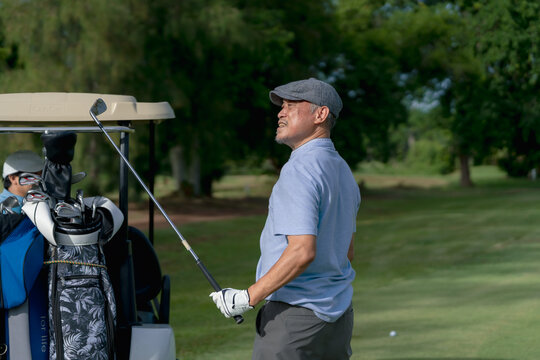 Active aging and golf friendship concept. Happy senior golfer shakes hands with a younger man on a green golf course, celebrating a friendly game. Golf, senior, handshake, friendship, sports.