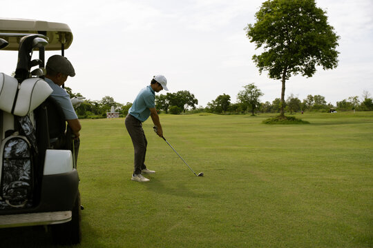 Active aging and golf friendship concept. Happy senior golfer shakes hands with a younger man on a green golf course, celebrating a friendly game. Golf, senior, handshake, friendship, sports.