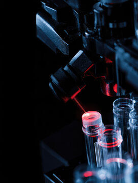 Microscope test tube laser laboratory dark blue red clinical precision equipment captures glowing test tube during laser analysis dark laboratory, with blue metal hardware, red light