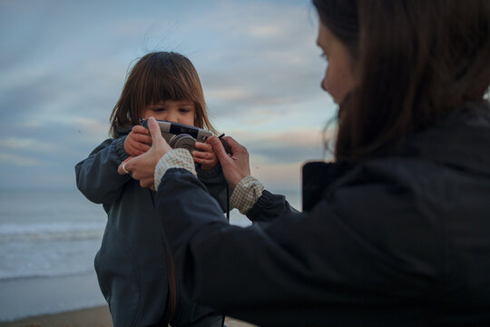 Mother Helping Child Use Camera on Beach