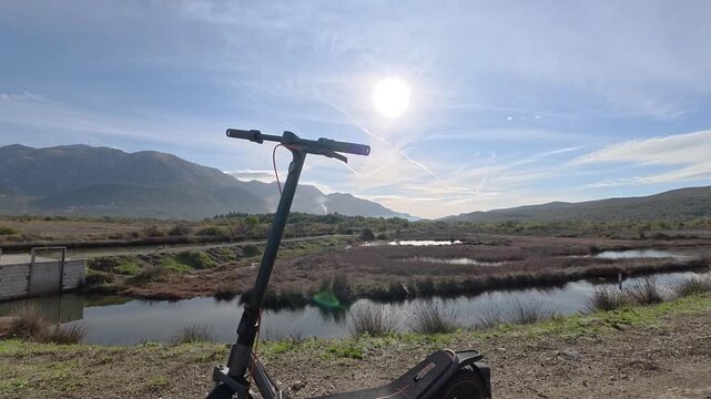 Moving Reveal of an Electric Scooter Beside Wetland Water