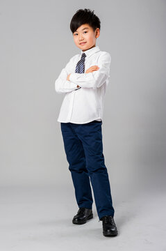 Portrait of handsome asian schoolboy in formal uniform in studio