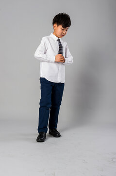 Portrait of handsome asian schoolboy in formal uniform in studio