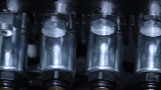 Metal valve cylinders row close up. Camera pan industrial machinery factory.