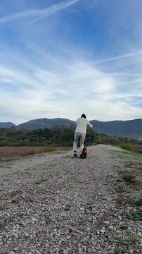 Man Pushing Off on an Electric Scooter in Vertical View