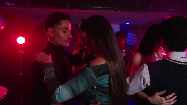 Happy couple dancing at nightclub party with neon lights