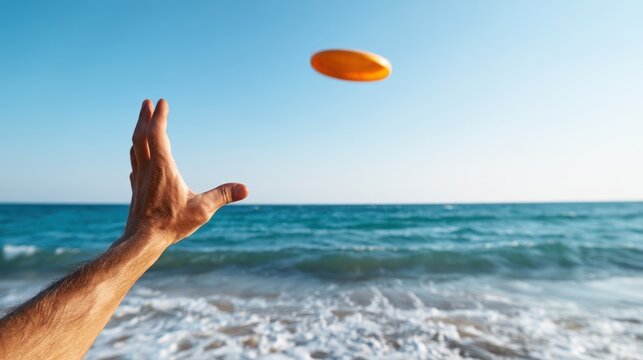 Hand reaching to catch orange disc above surf at beach